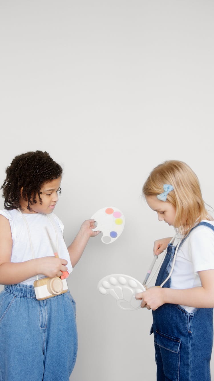 Two Kids Holding A Paintbrush And A Palette