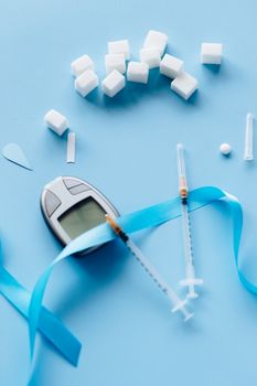 Flat lay of diabetes awareness items including glucometer and insulin syringes.
