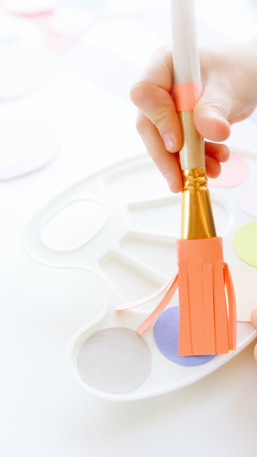 Close-Up View of a Kid Holding a Paintbrush