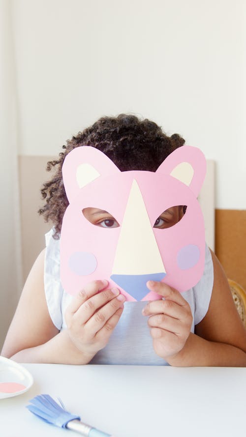 Girl Covering Her Face With a Cutout Animal Mask