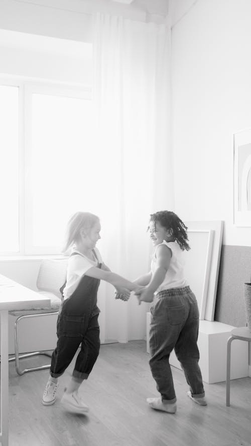 Monochrome Photo of Two Girls Playing