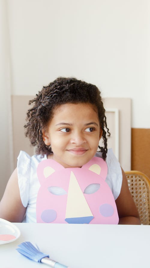 Girl Looking Away While Holding a Paper Animal Mask