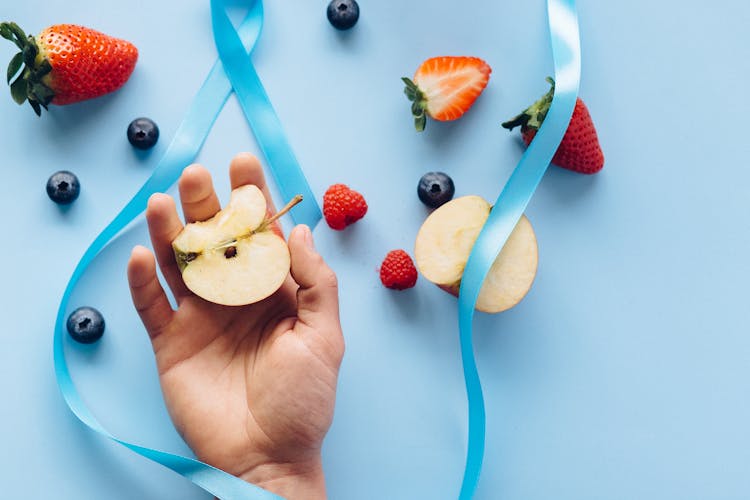 Person Holding A Sliced Of Apple 