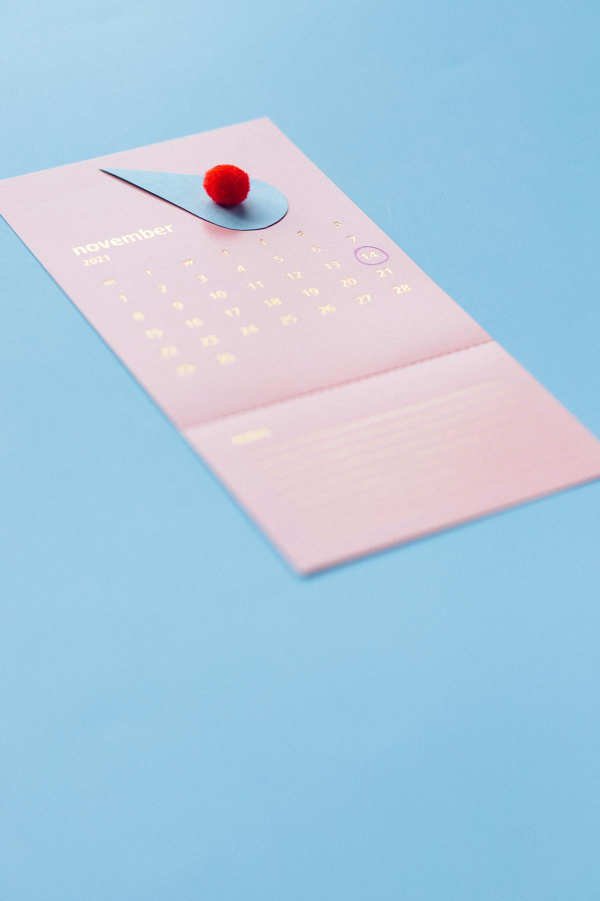 A person holding a weekly pill organizer next to a plate of healthy food