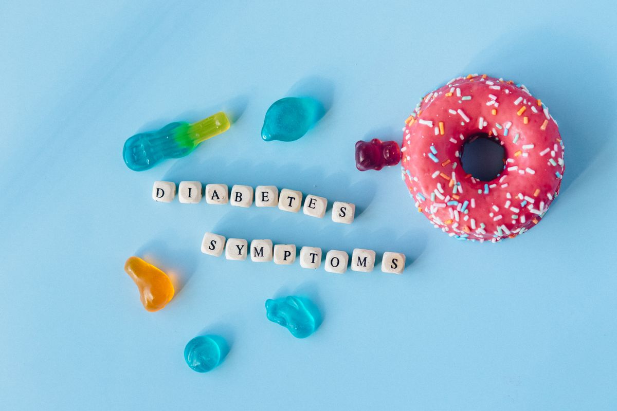 Colorful sweets on blue surface signifying diabetes symptoms.