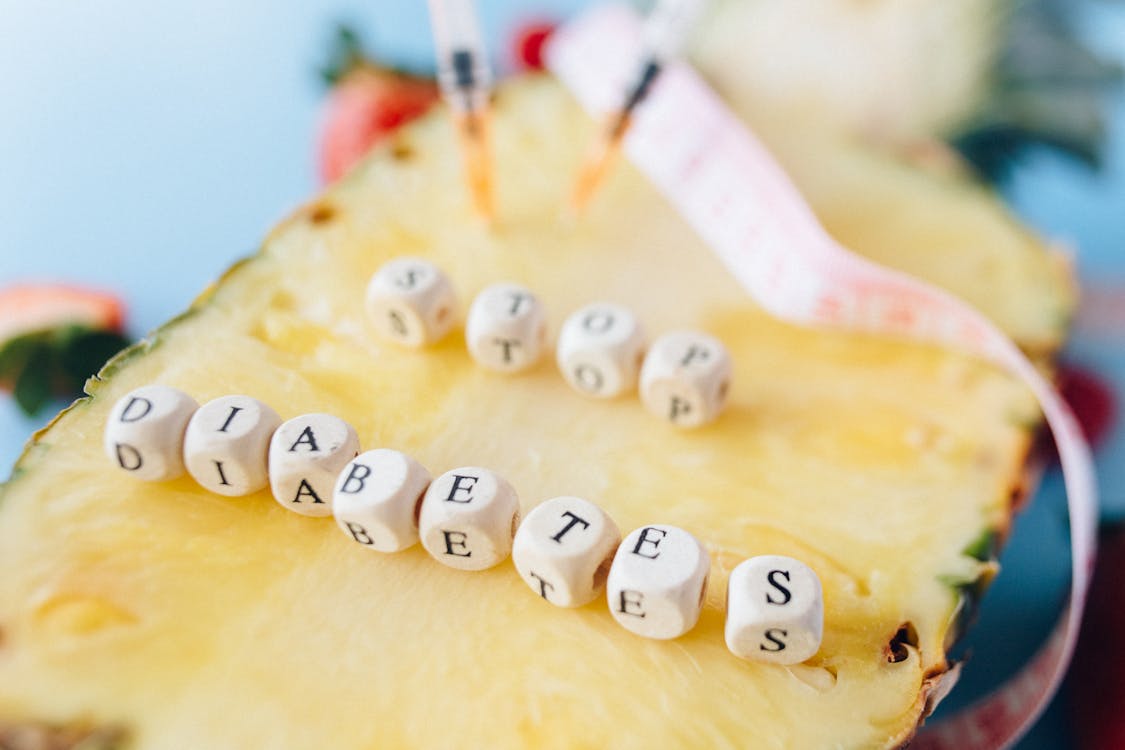 Letter Dices over a Cut Pineapple Fruit