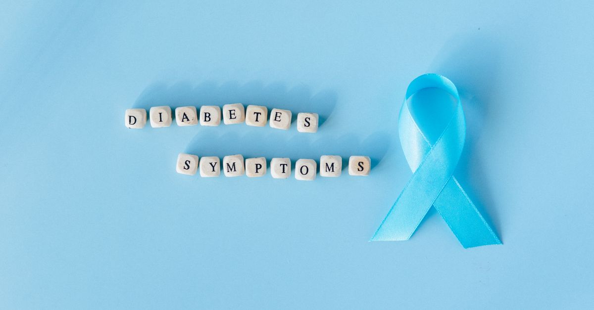 Conceptual image emphasizing diabetes symptoms with a blue awareness ribbon and letter dice.