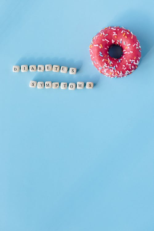 Letter Dices with Message Beside a Donut on a Blue Surface