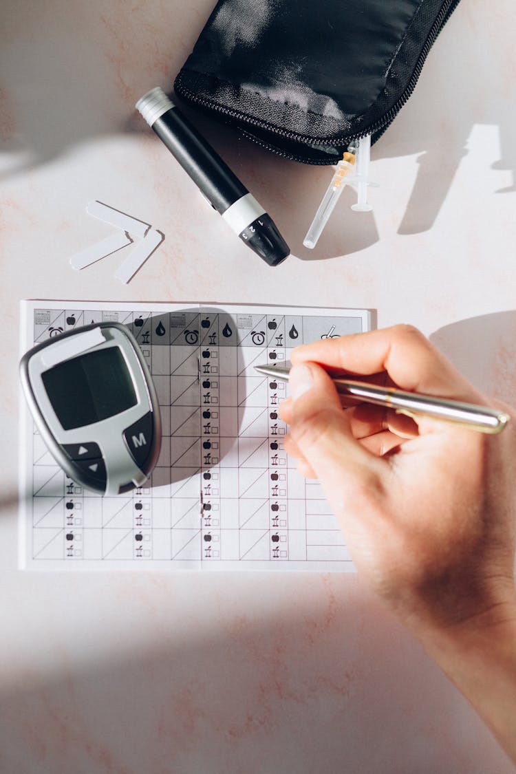 A Person Recording His Blood Sugar Reading