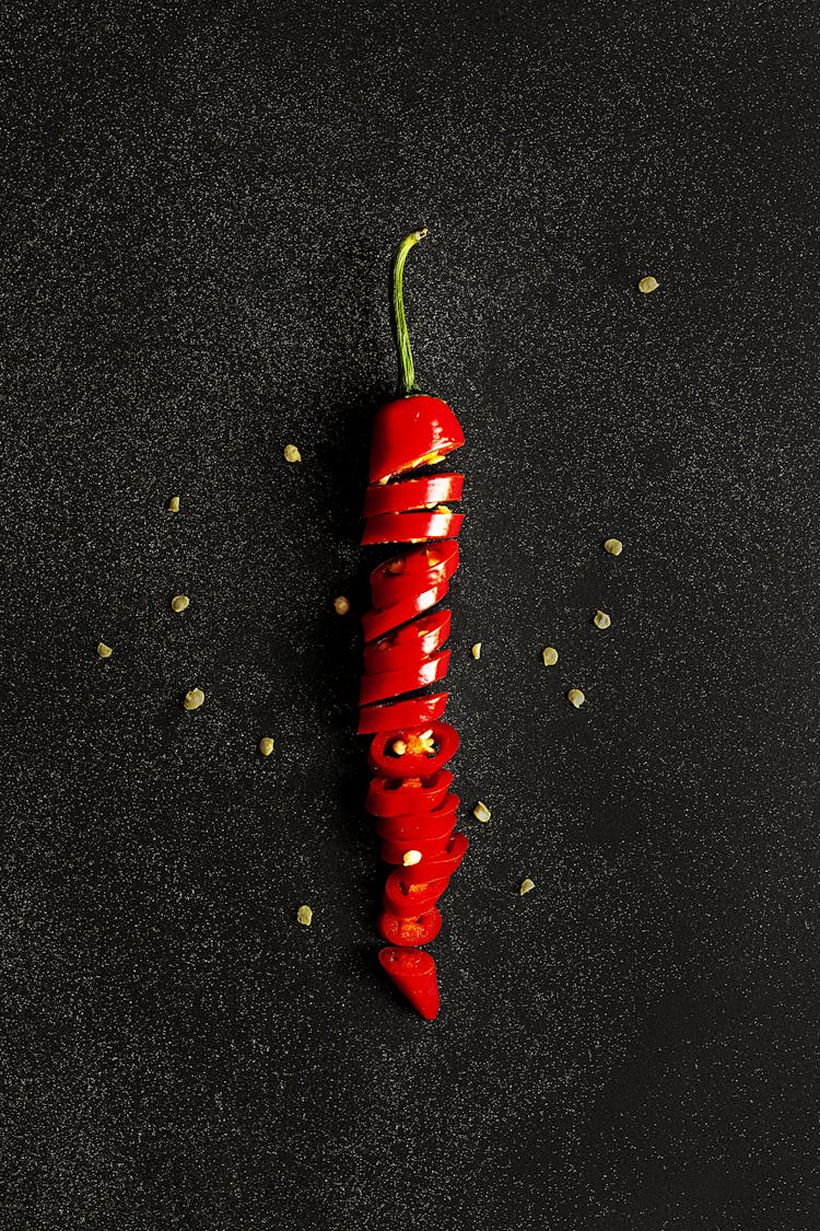 Sliced Red Chili Pepper On Black Surface