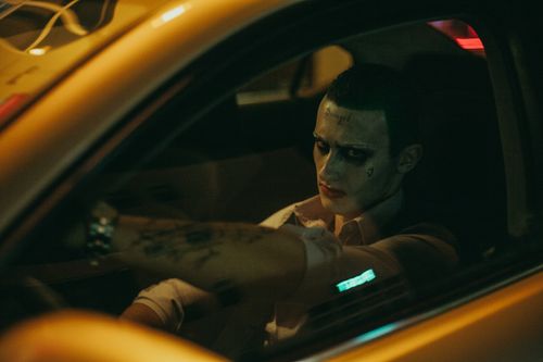 Free Confident male cosplayer with tattoos sitting in yellow automobile in city street while looking at camera at night Stock Photo