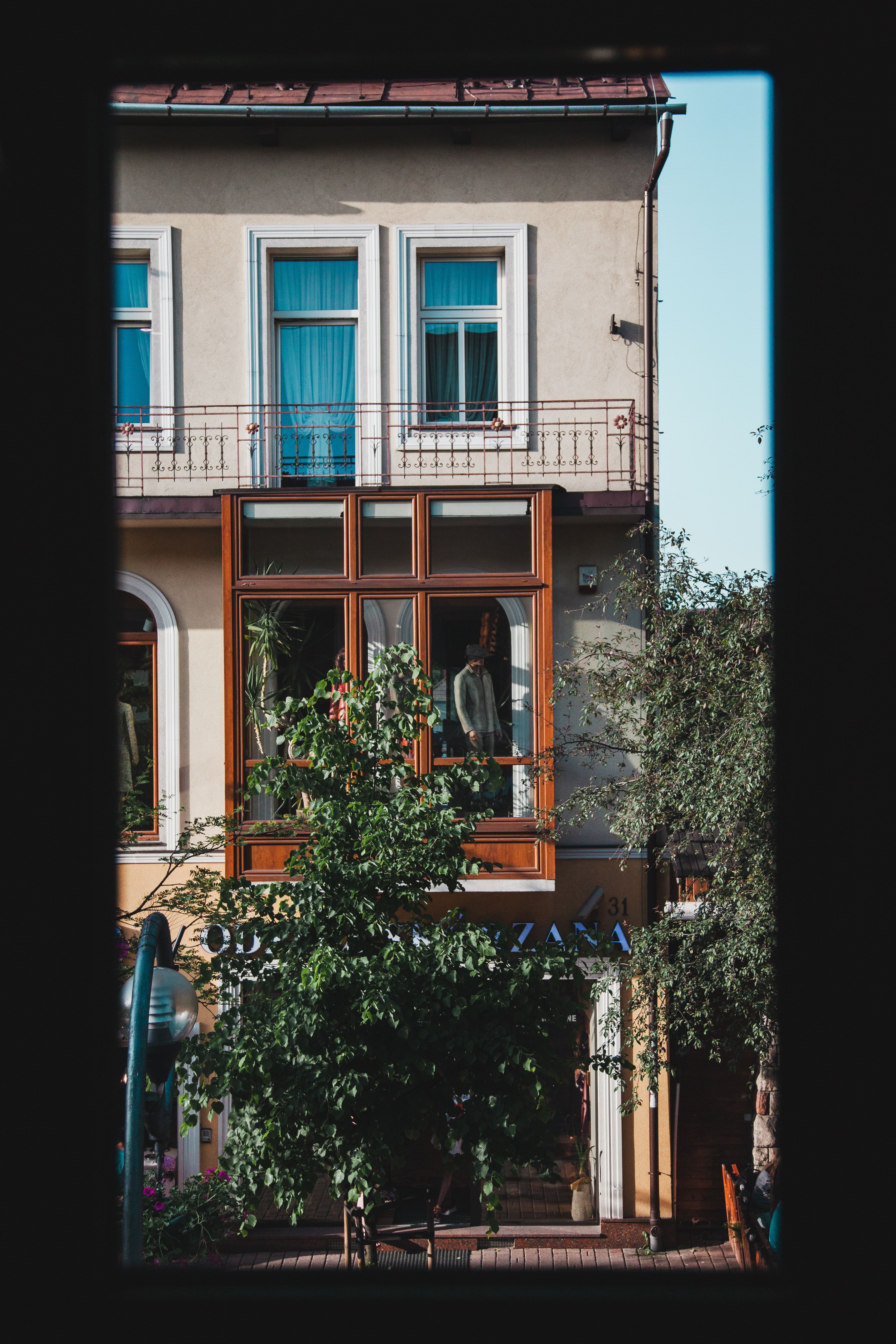 Façade d’immeuble ancien aux fenêtres alignées, vue depuis la rue.