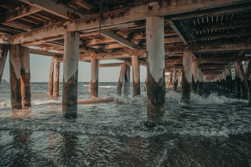 Waving sea under shabby bridge