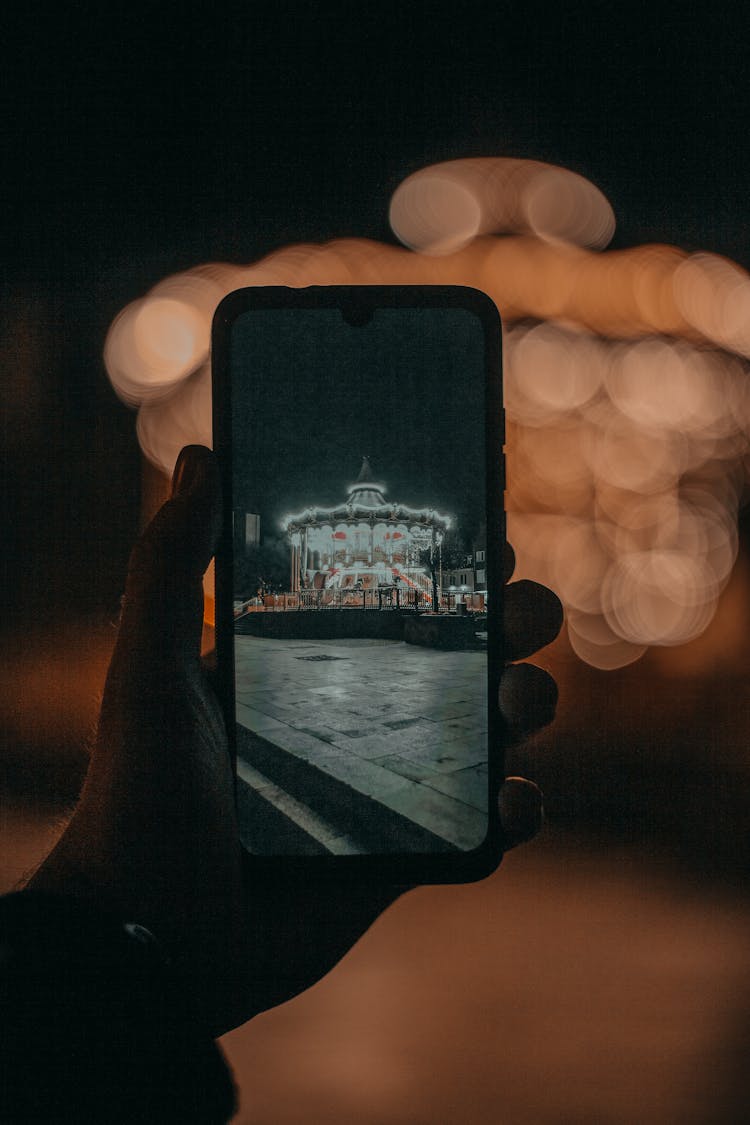 Crop Person Taking Photo Of Attraction In Darkness