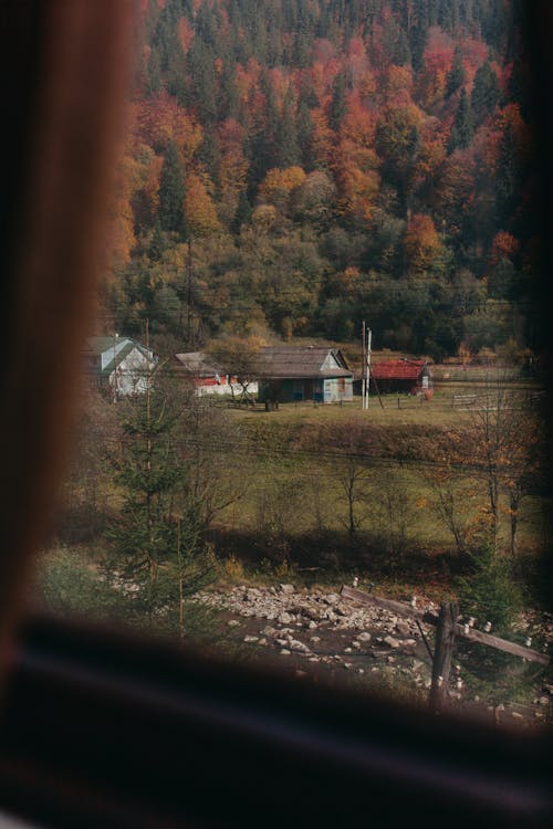 Small village surrounded by mountains covered with lush autumn woods