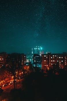 Beautiful city skyline illuminated under a vibrant night sky full of stars. Perfect urban night scene.