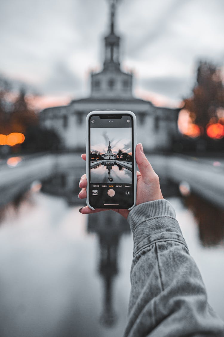 Crop Unrecognizable Woman Taking Photo Of Aged Building On Smartphone During Vacation