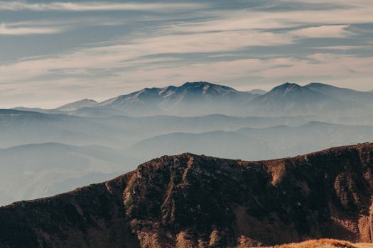 A breathtaking view of a mountain range enveloped in mist at sunrise, showcasing nature's beauty.