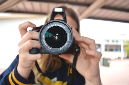 Orang Yang Memegang Kamera Dslr Hitam