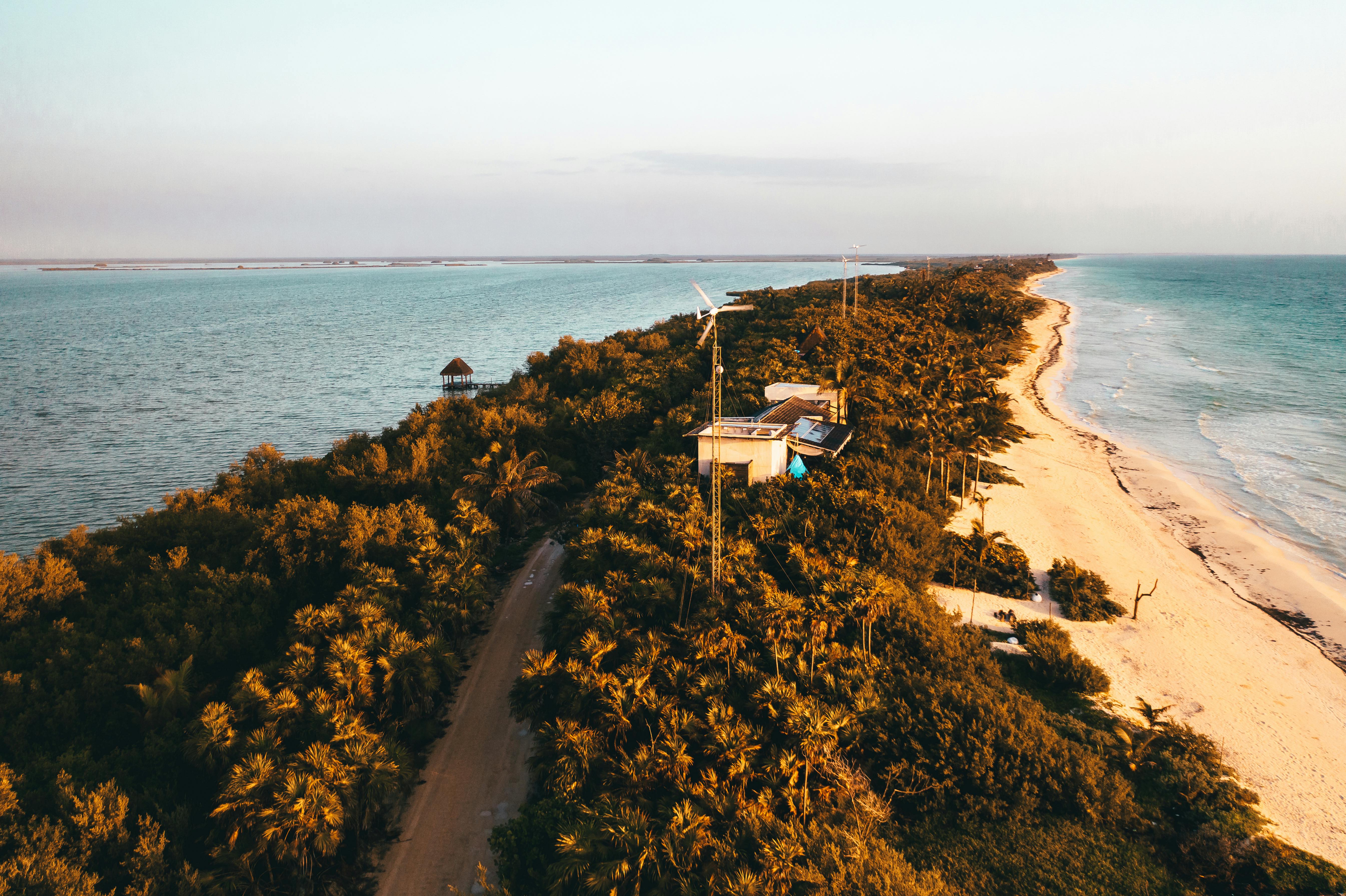 white and brown house on brown sand near body of water