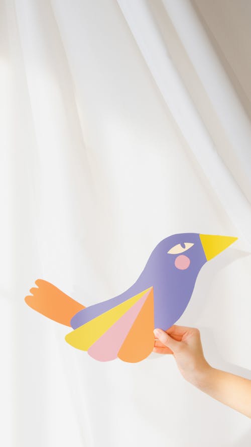 Person Holding a Colorful Paper Bird