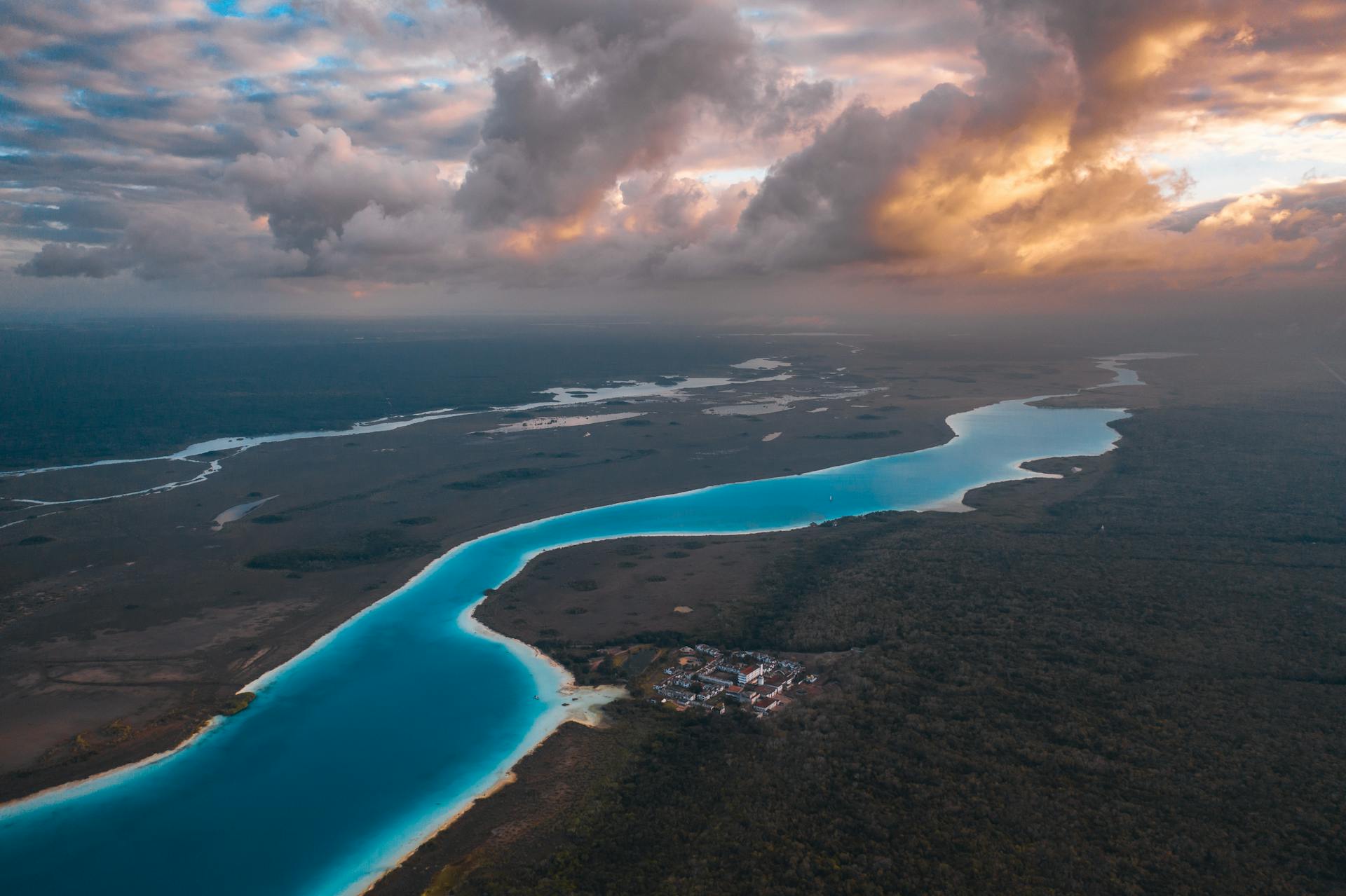 Stunning drone shot of a river bend with a dramatic sunset sky, showcasing nature's beauty.