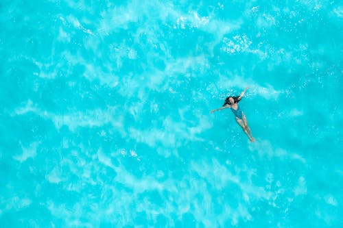 Aerial Photo of a Woman Floating in the Ocean