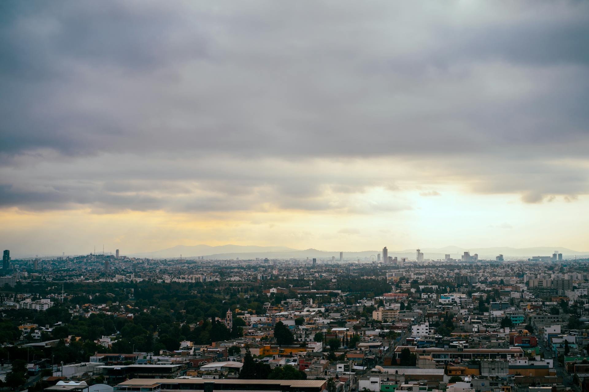 A breathtaking aerial shot of Mexico City with cloudy skies and sprawling urban landscape.