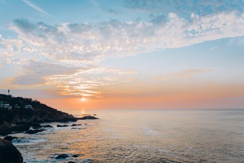 Free Breathtaking Mexican coastline with colorful sunset hues over the ocean. Ideal for travel inspiration. Stock Photo