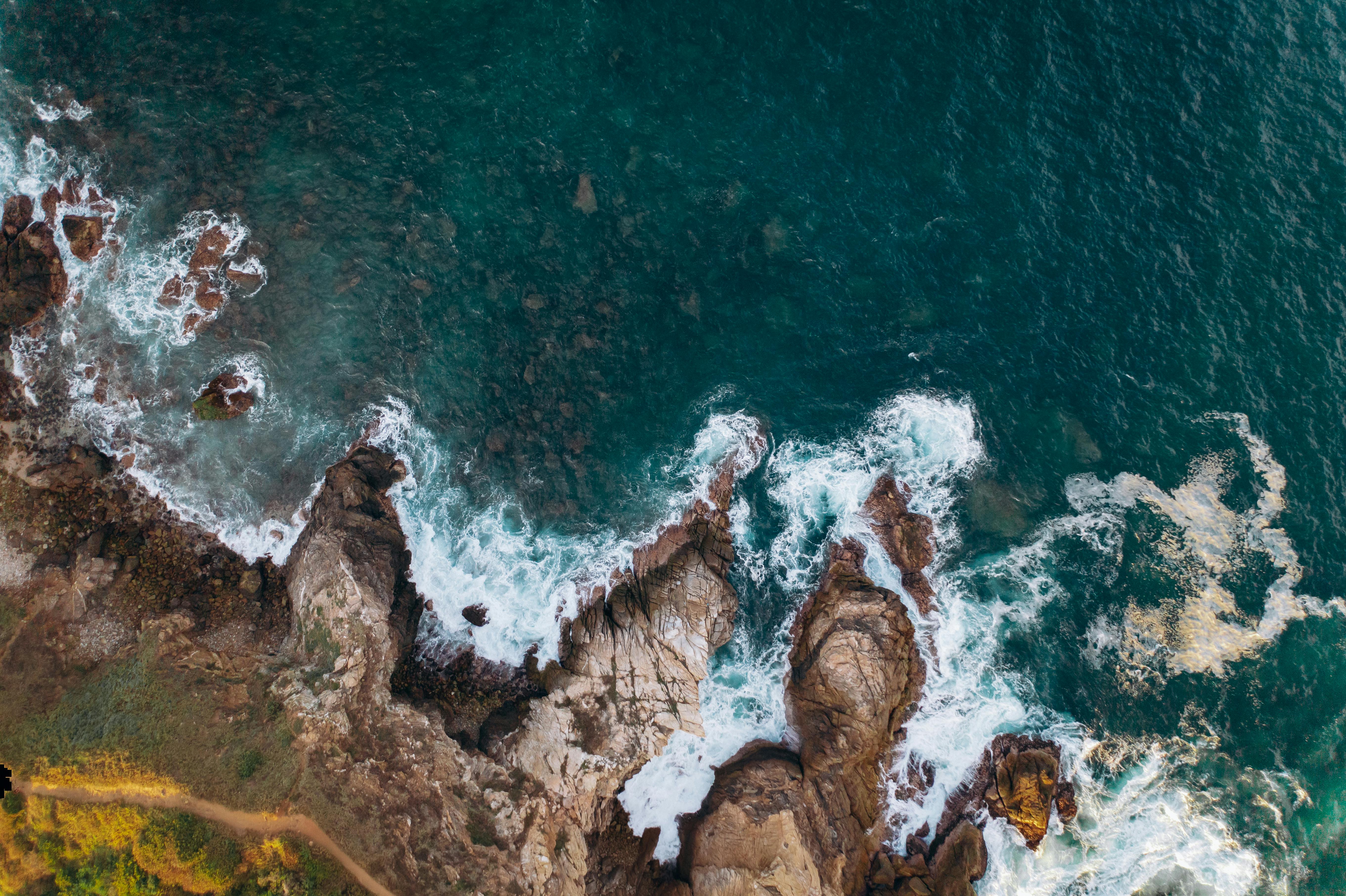 brown rocky shore with blue water