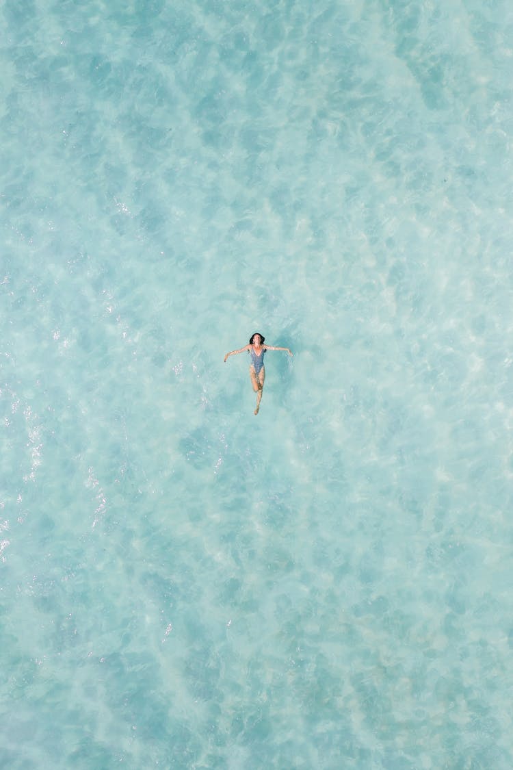 Drone Shot Of A Woman Floating On The Water