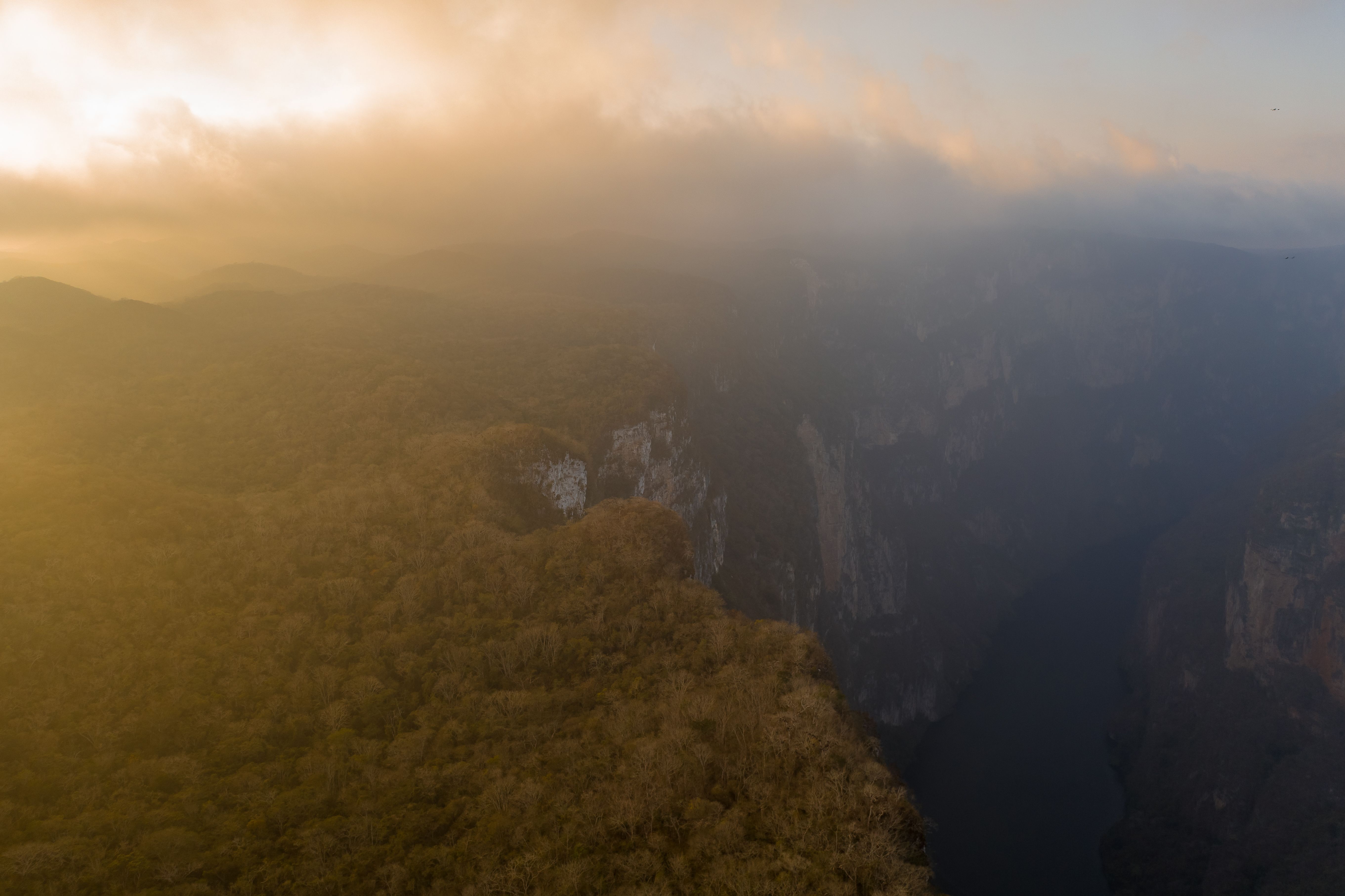 Aerial view of a fog-covered canyon at sunset