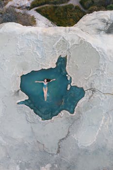 Aerial shot of a woman swimming in a natural thermal pool in Oaxaca, Mexico.