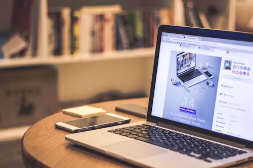 Free Silver Laptop Computer Beside White Smartphone on Brown Wooden Table Stock Photo