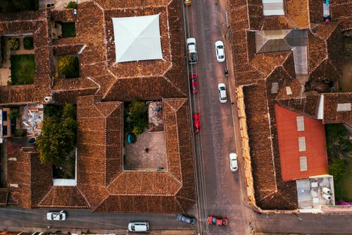Free Aerial view showcasing traditional Mexican architecture with bustling street and colorful rooftops. Stock Photo