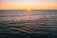 令人惊叹的太阳落山在海洋上，在海浪上投下温暖的光芒