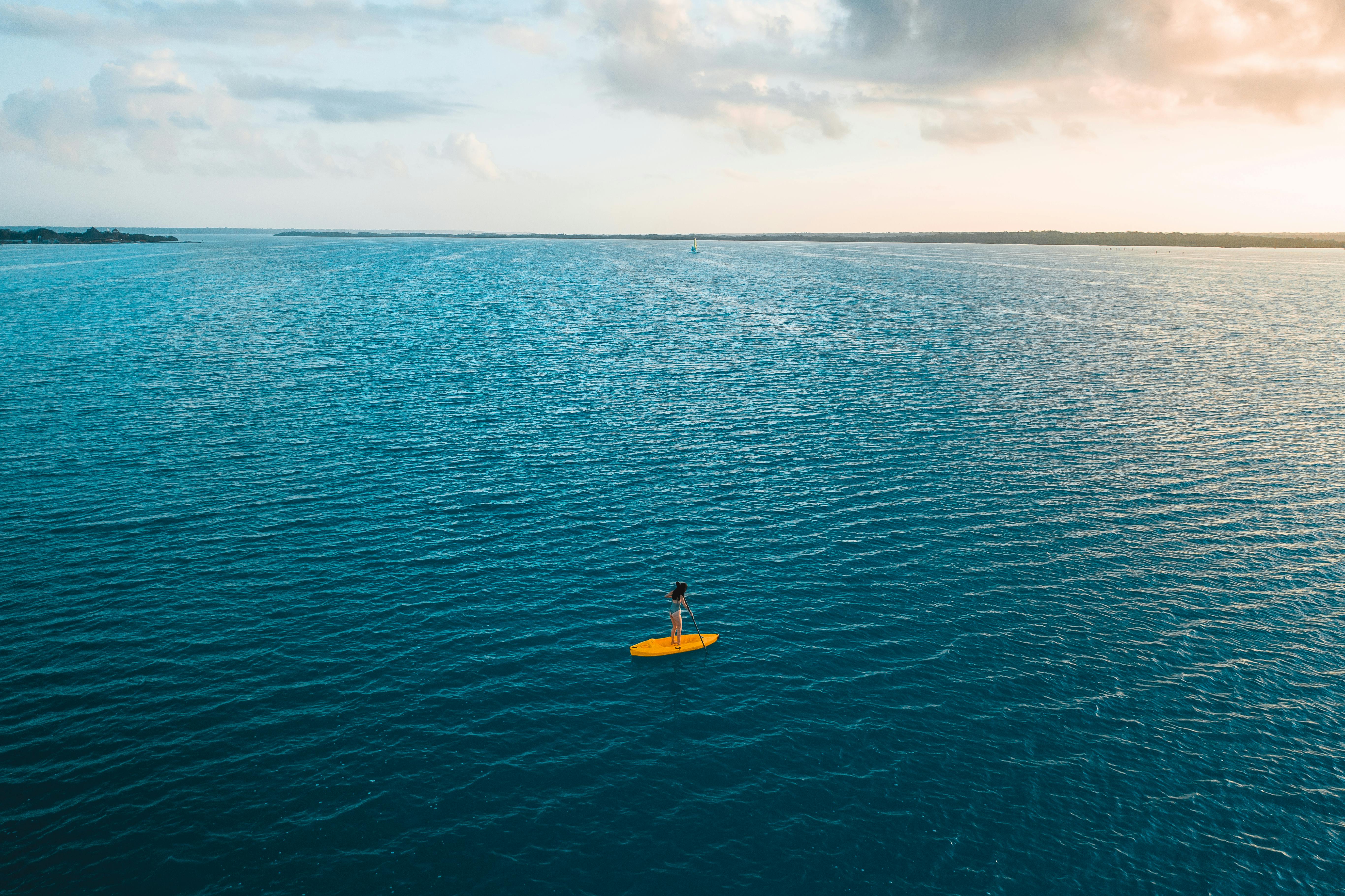 yellow and black kayak on blue sea under blue sky