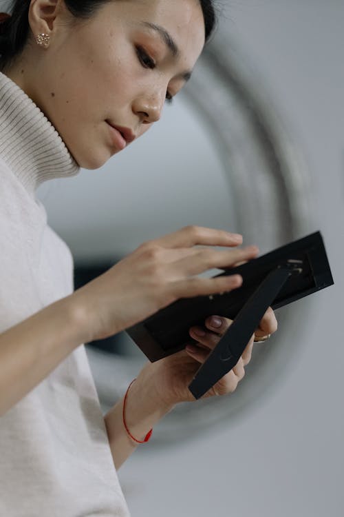 Woman in White Shirt Holding Black Smartphone