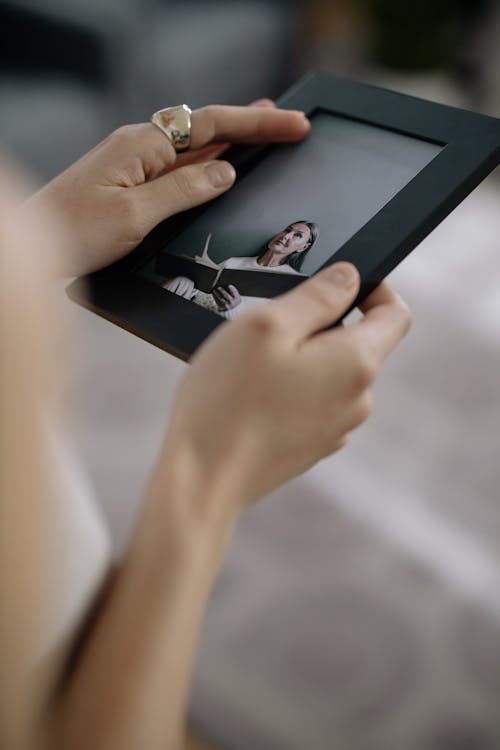 Close-Up Shot of a Person Holding a Picture Frame