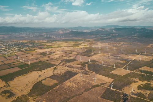 Free A breathtaking aerial shot of wind turbines on a rural Mexican landscape with mountains. Stock Photo
