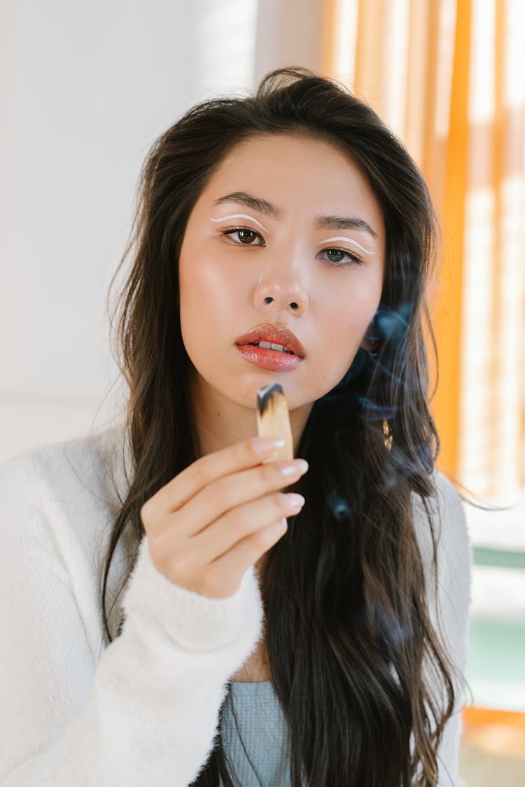 A Woman Holding A Palo Santo