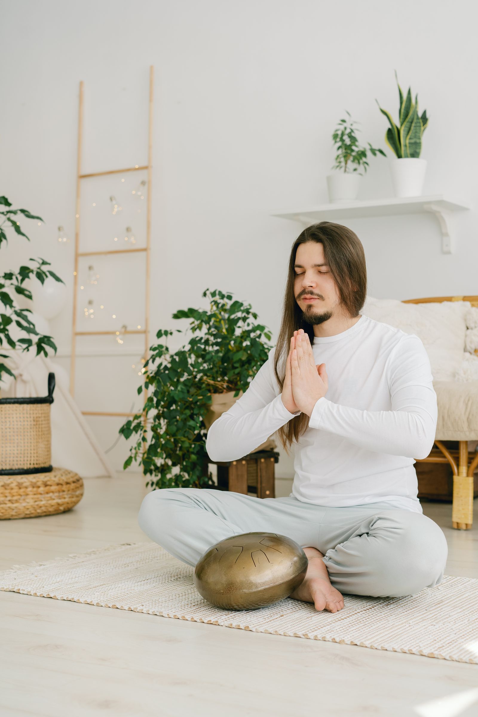 Person meditating in lotus pose with hands in prayer position