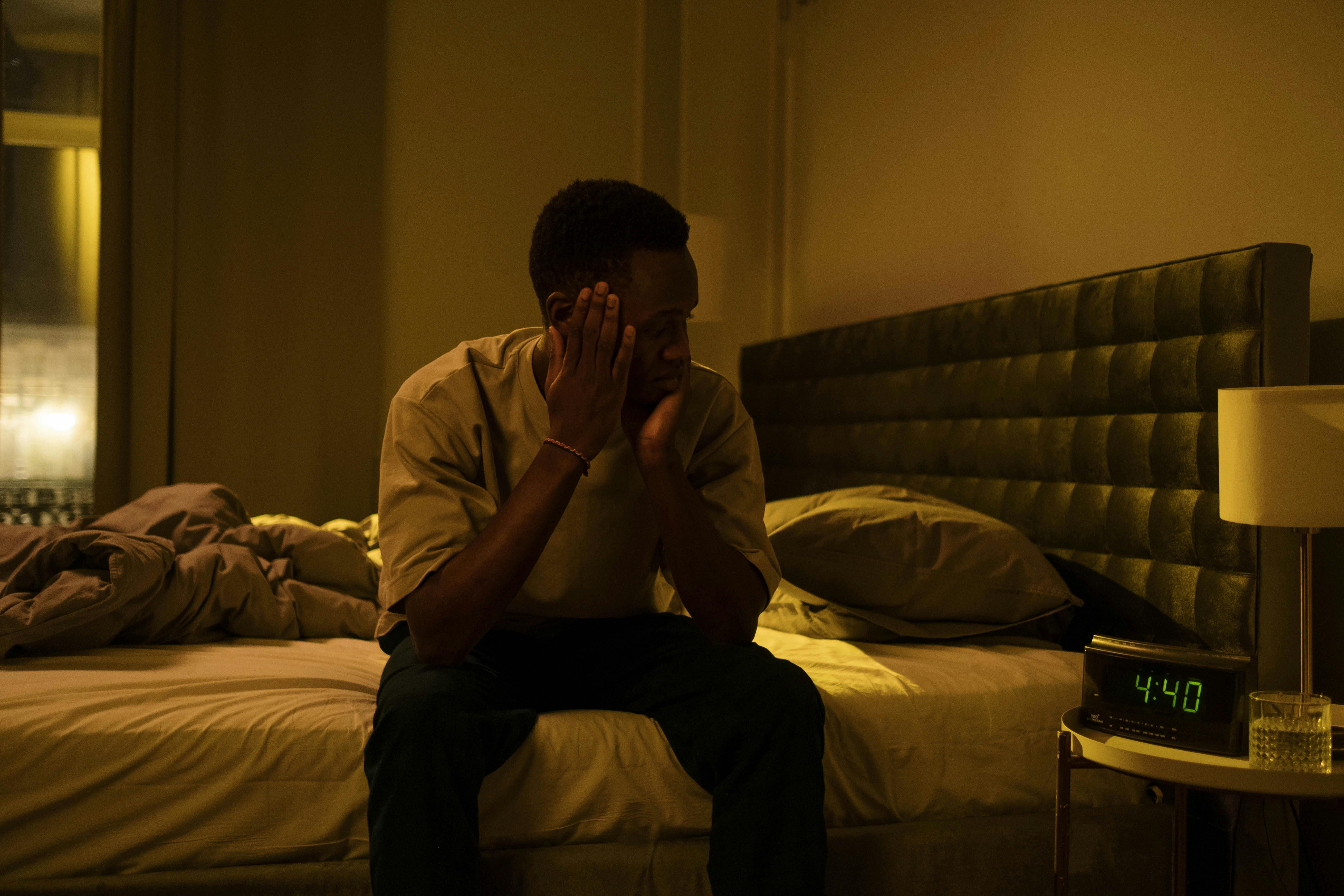 Image of a man sitting on bed