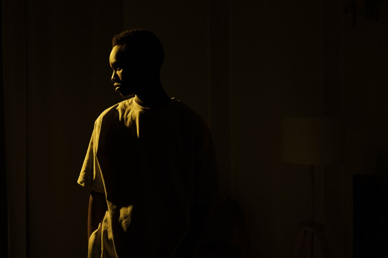silhouetted adult man standing indoors embodying introspection and sol