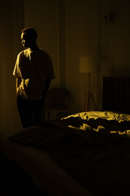 Photo of Man Standing Beside the Bed