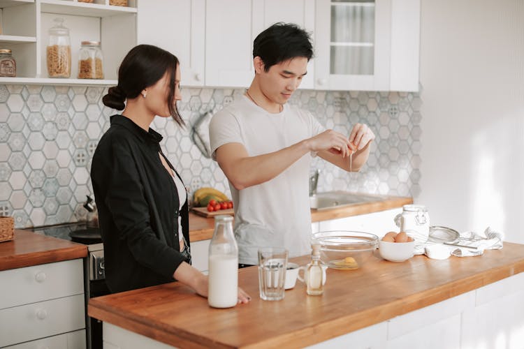 
A Couple Preparing Food In The Kitchen