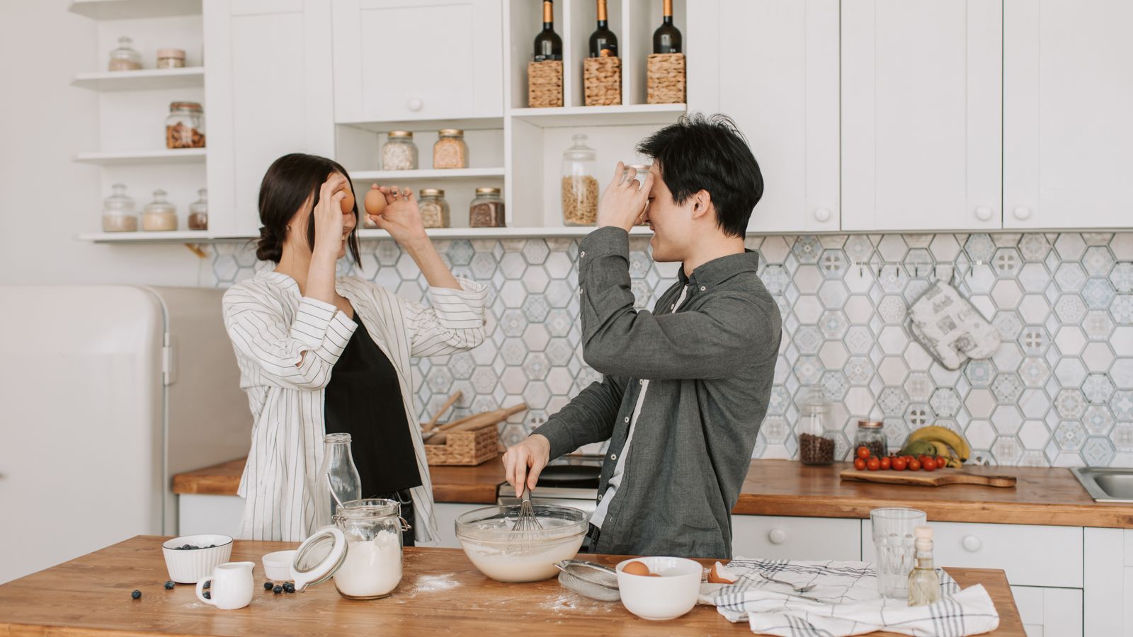 Two adults preparing ingredients together in a kitchen