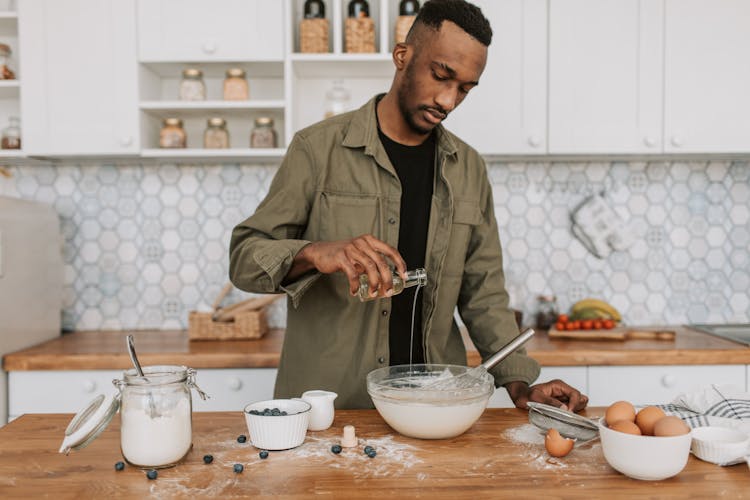 Man In Jacket Pouring Syrup On Bowl 