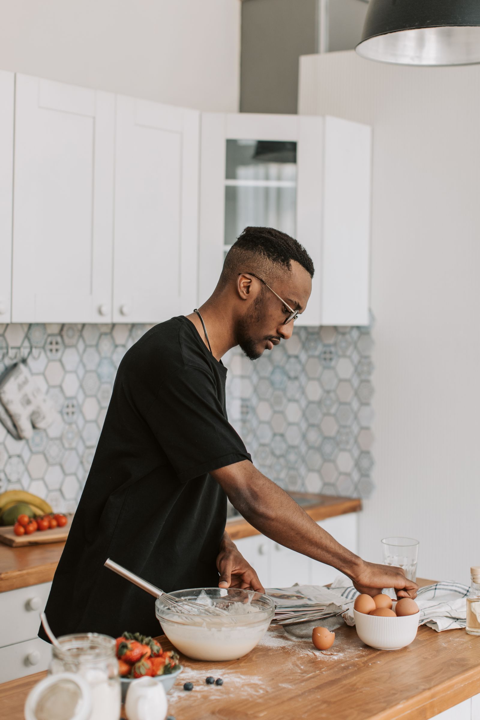 Black man in a kitchen preparing food, exemplifying home cooking and lifestyle choices.