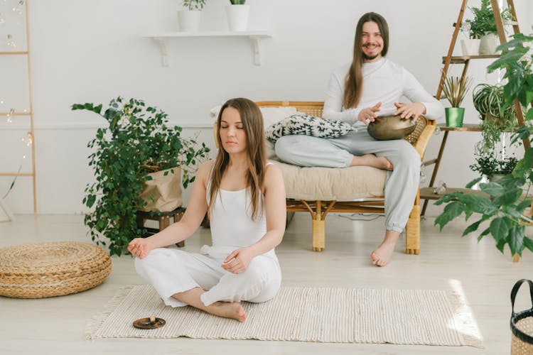 A Couple Meditating At Home